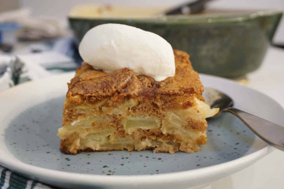 vanilla ice cream on golden apple cake white rimmed blue plate