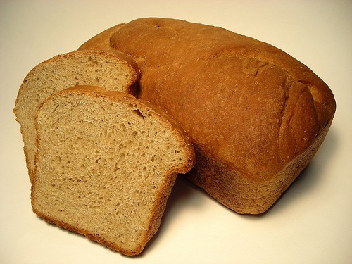 Wheat Bread loaf behind two slices