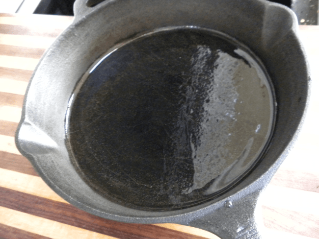 spreading olive oil on cast iron pan