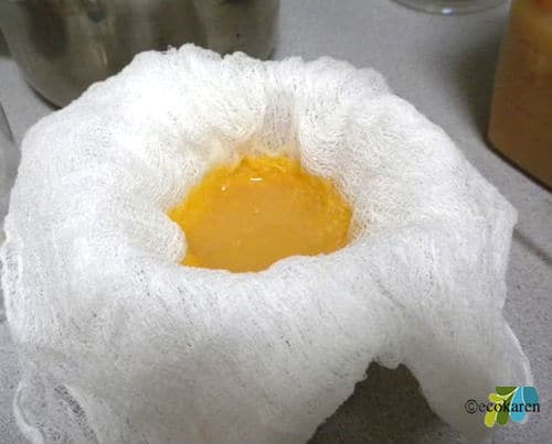 straining citrus enzyme cleaner in cheese cloth