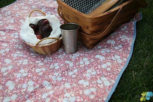 picnic basket and fruit basket on top of Waterproof Picnic Blanket