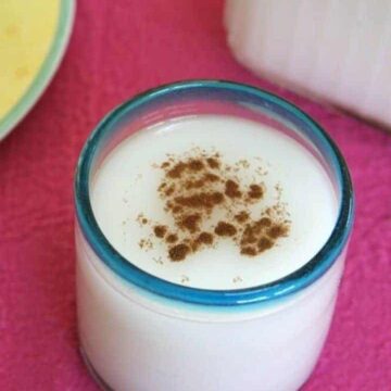 Rice Milk in a blue rimmed glass on a pink placemat