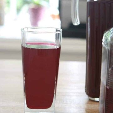 Glass of red beet kavas on a wooden table