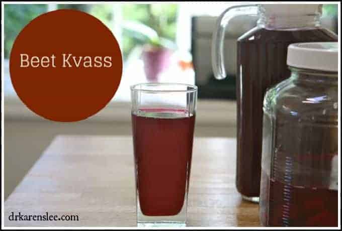 Beet kvass in a glass next to beet kvass pitcher