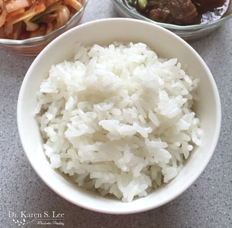 bowl of white rice in front of bowl of kimchi and bowl of bulgogi