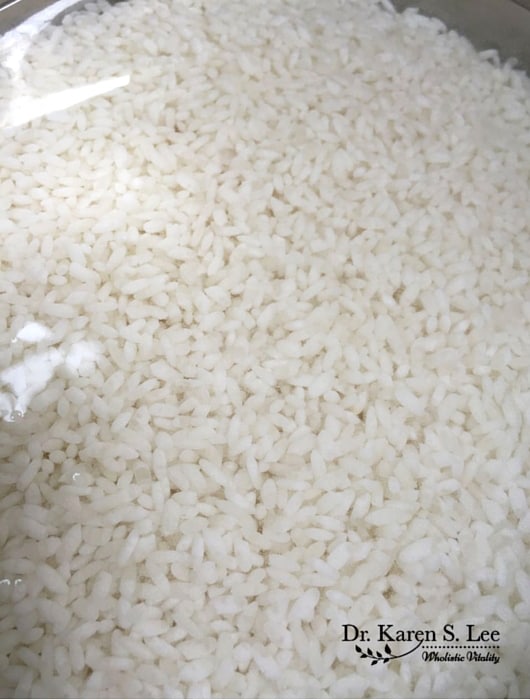 soaked white rice being rinsed until water is clear