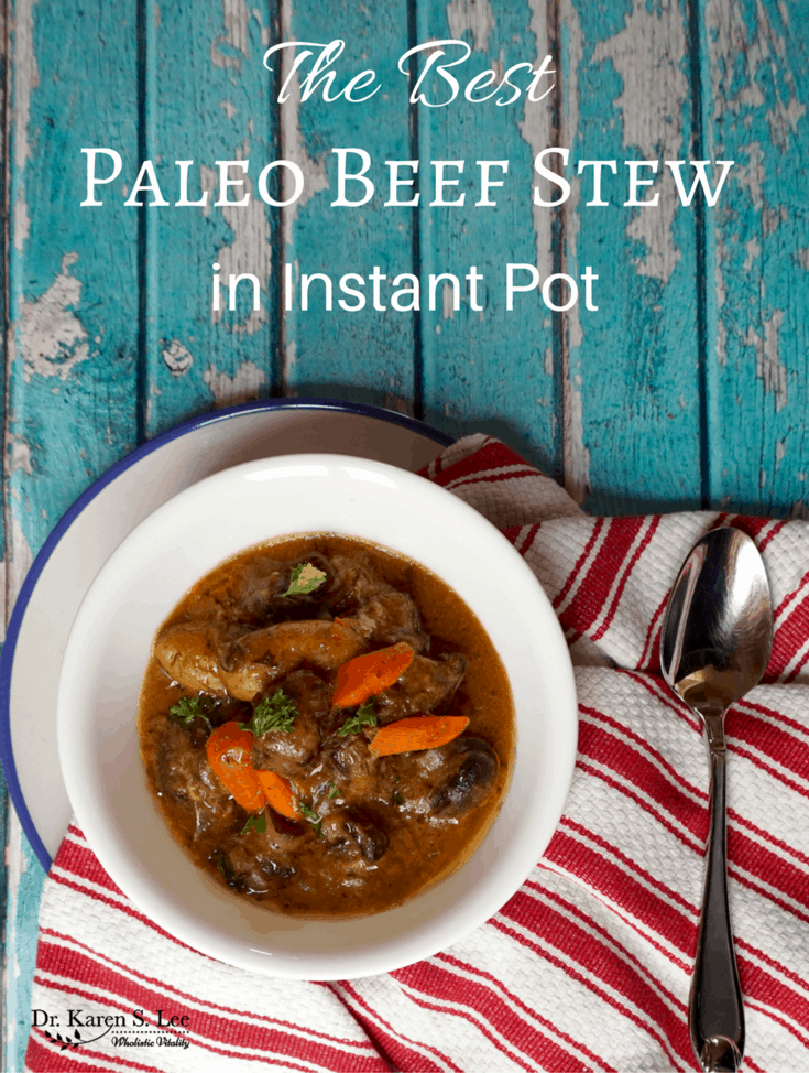 Paleo beef stew in white bowl next to spoon on red white stripe towel