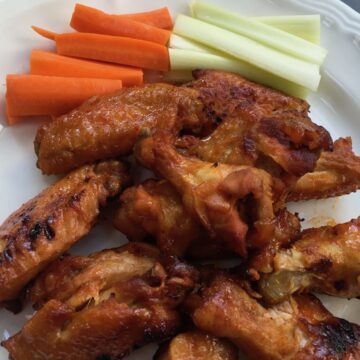 chicken wings, carrots, celery sticks on white plate