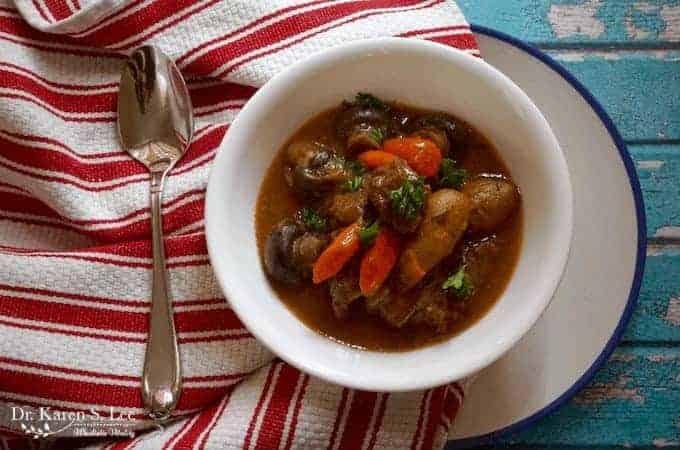 Paleo beef stew in white bowl on red white stripe towel