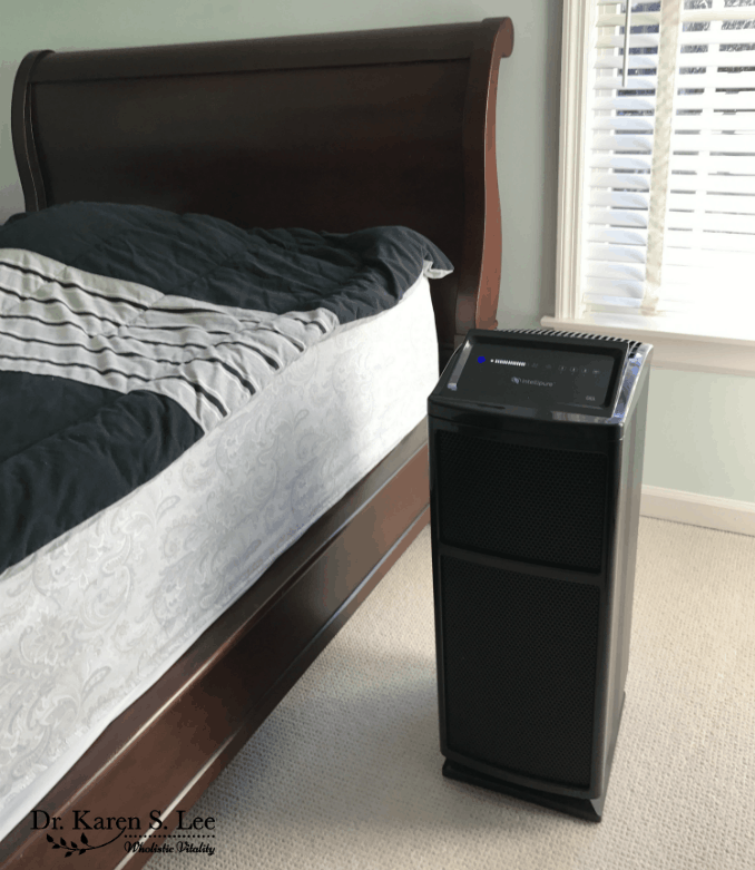 intellipure fine particle air filtration machine next to bed