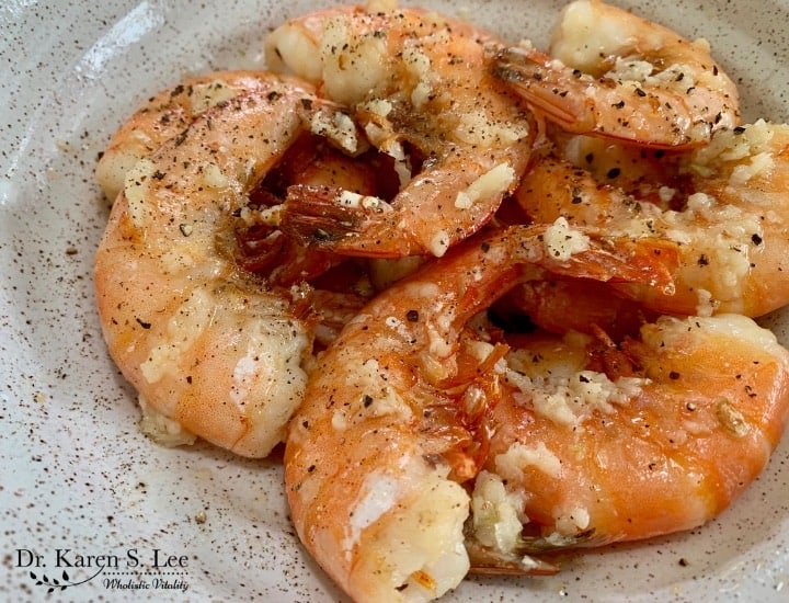 close up cooked shrimp in a black specked bowl