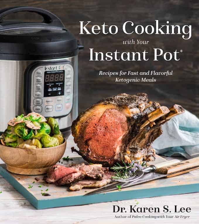 Prime Rib Roast on a wooden board with a bowl of Brussels Sprouts with Instant Pot pressure cooker in the background on the cover of KetoCooking with your Instant Pot cookbook