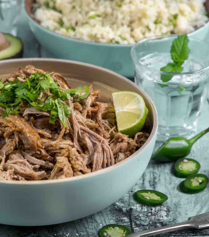 shredded pork in a round platter with lime wedge and cilantro on top