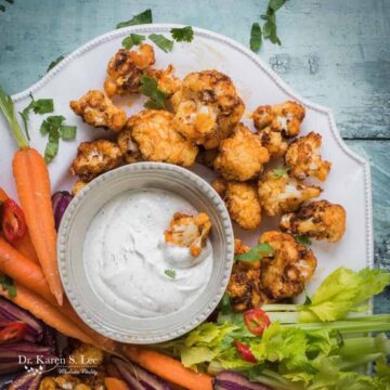 Buffalo Cauliflower Bites with assorted vegetables around ranch dressing bowl