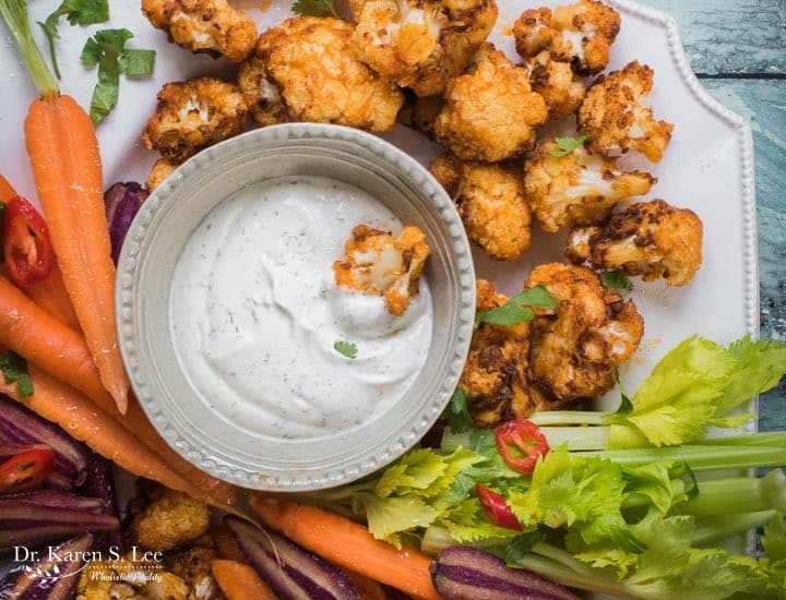 Buffalo Cauliflower Bites with assorted vegetables around ranch dressing bowl