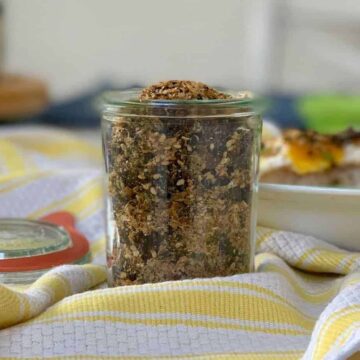 Furikake in a glass jar on a yellow and white stripe kitchen towel