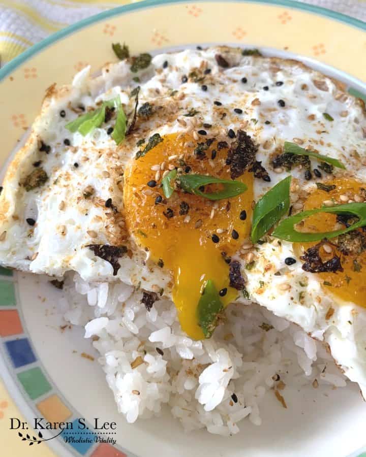 Furikake sprinkled on a plate of white rice and sunny side up eggs with runny yolk