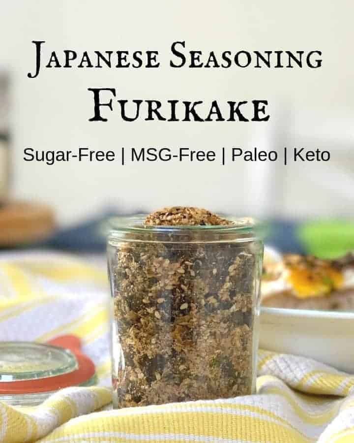 Japanese seasoning furikake with nori in a glass jar on yellow and white stripe kitchen towel with title Japanese Seasoning Furikake above the jar