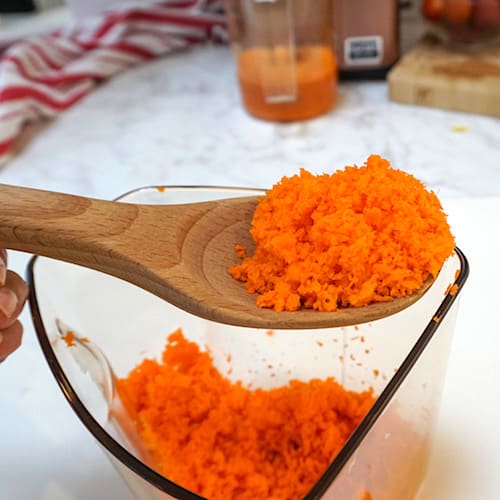 fine powdery carrot pulp on a wooden spoon