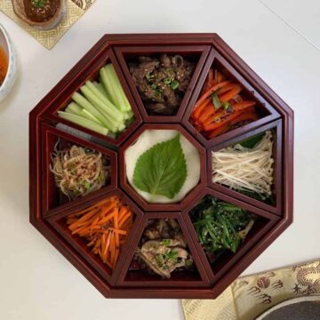 Colorful platter of nine vegetables in an octagonal wooden Korean dish