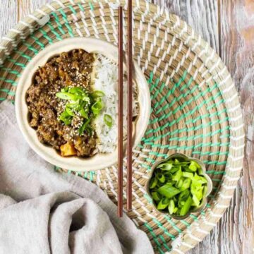 Ground Beef Bowl with white rice with chopsticks resting on top