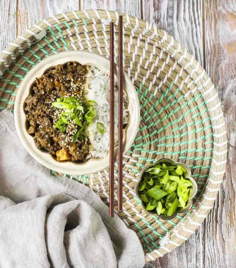 Ground Beef Bowl with white rice with chopsticks resting on top