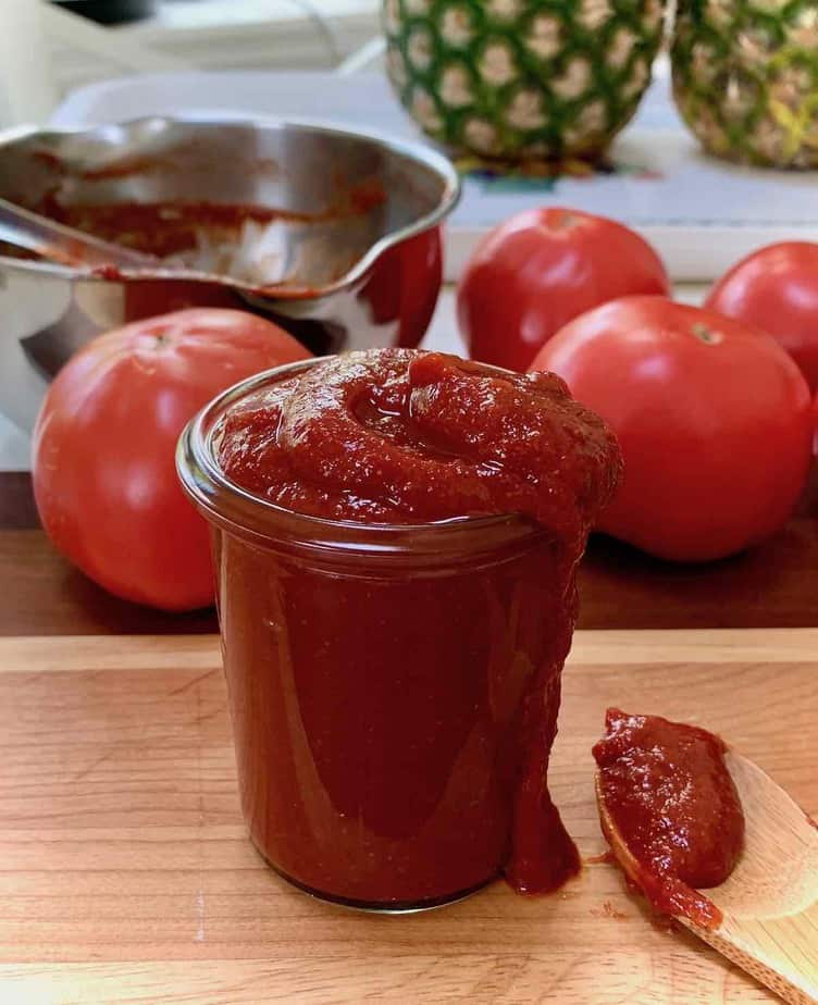 Ketchup in a glass bottle on wooden cutting board