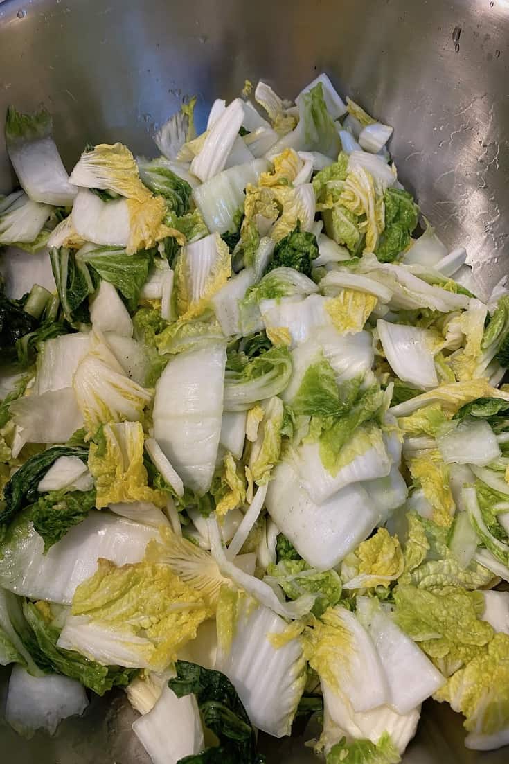 cabbages in a salt brine in a stainless steel bowl