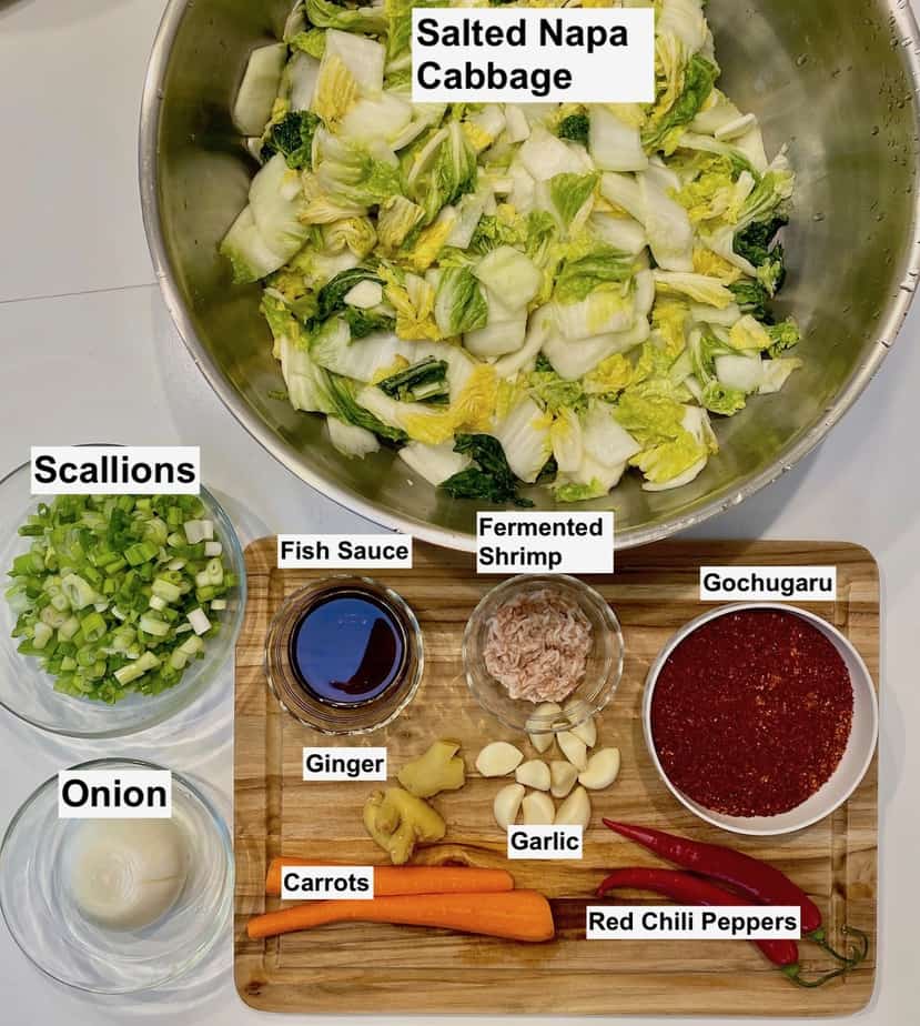 mis en place of kimchi ingredients on a white table and cutting board